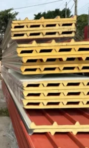 Πάνελ πολυουρεθάνης για οροφή μεταλλικής στέγης σε τραπεζοειδές σχήμα σε διάφορα μήκη με κόκκινο χρώμα, τοποθετημένα σε στοίβα